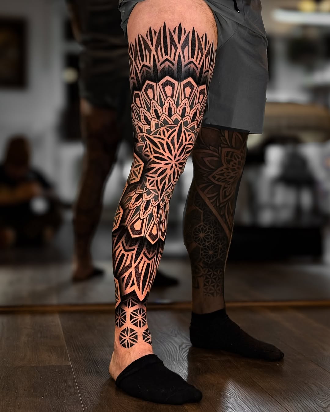Striking blackwork geometric mandala leg-sleeve with bold contrast.