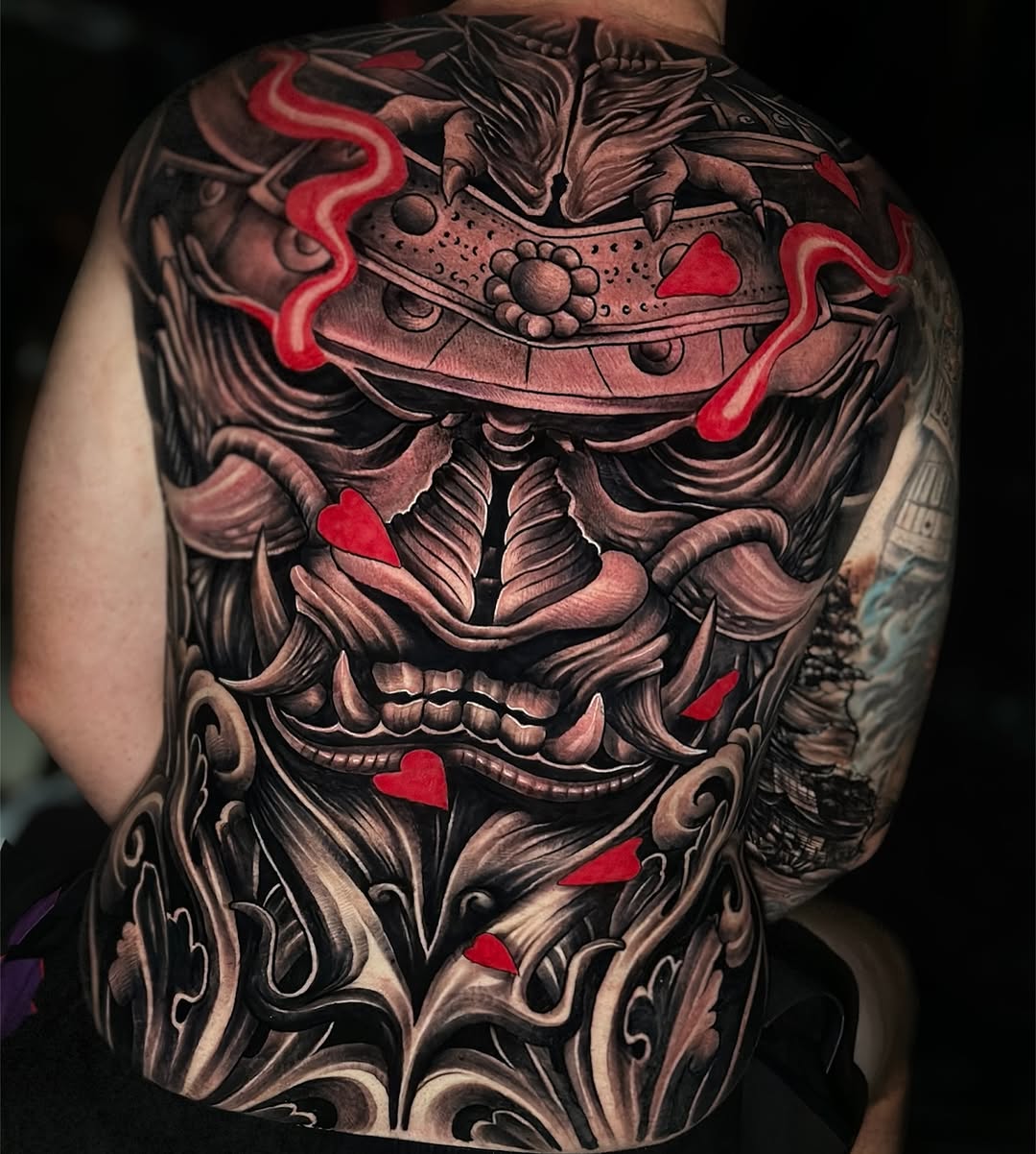 Monstrous blackwork back piece with crimson heart accents