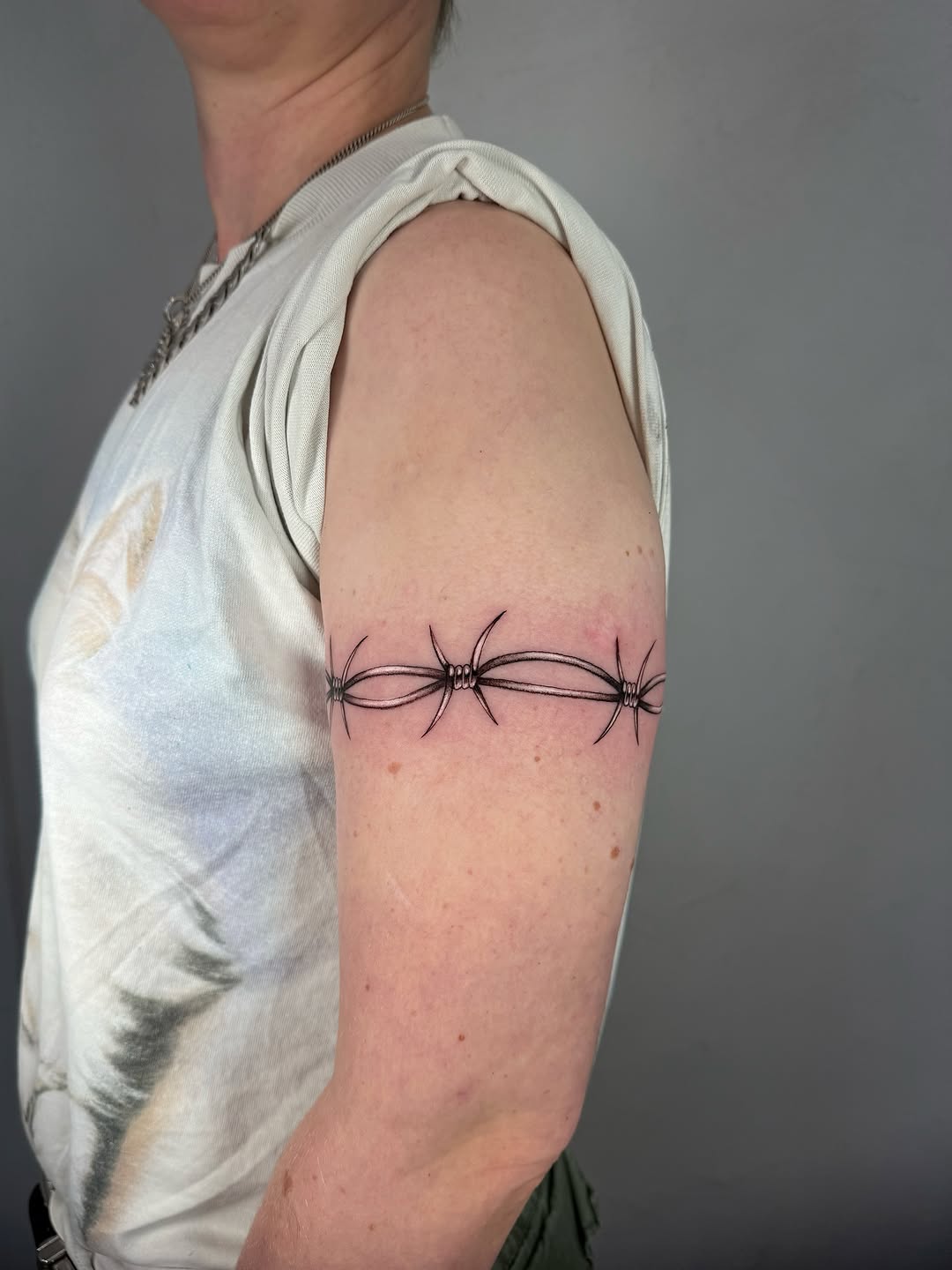 Bold, clean barbed-wire band with precise linework.