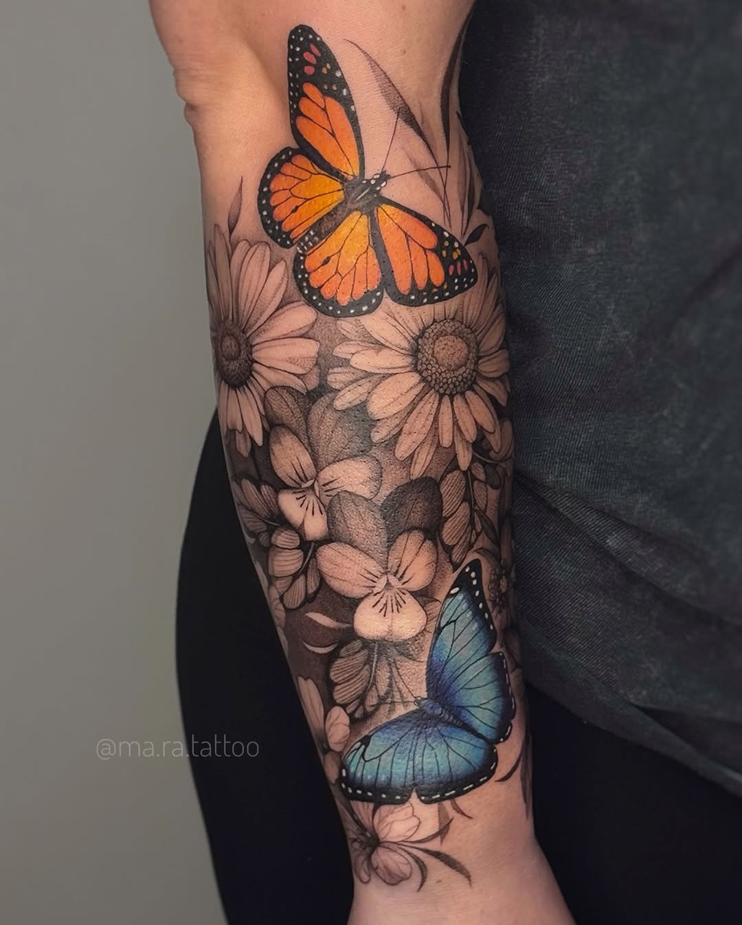 Vivid orange monarch and blue morpho butterflies amid grayscale florals