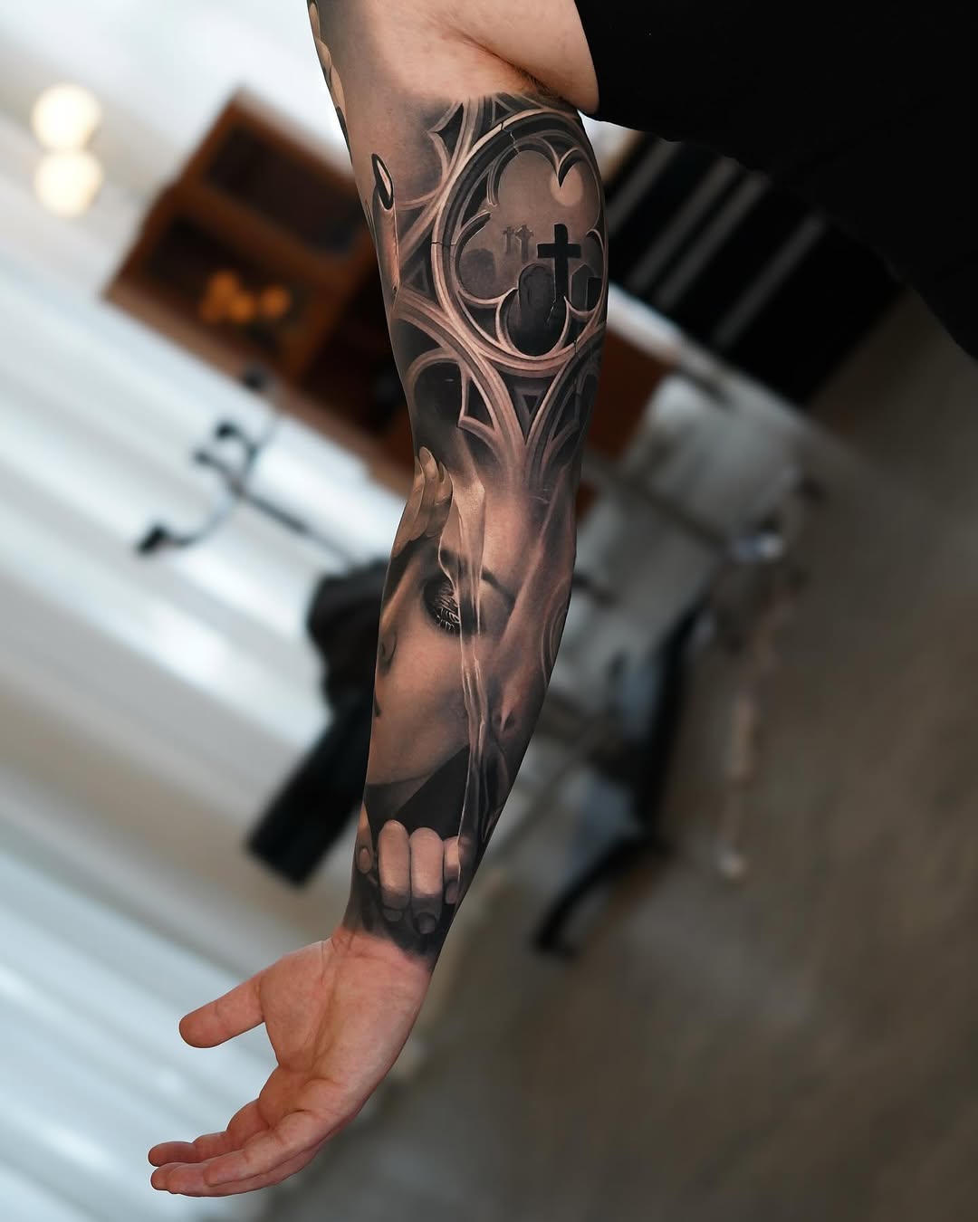 Hyper-detailed grayscale forearm sleeve with sculpted face and arches