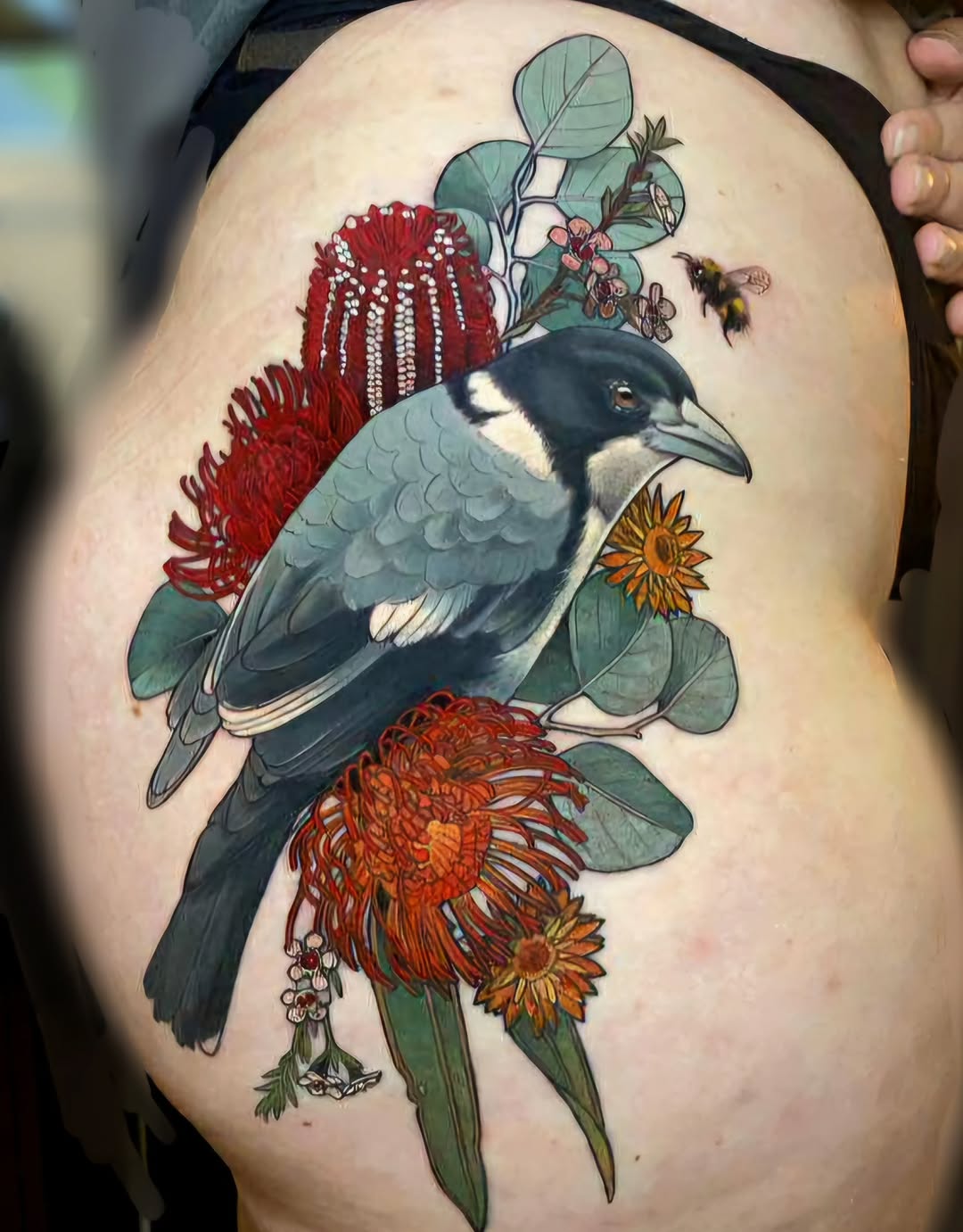 Vivid butcher bird perched among bold tropical blooms