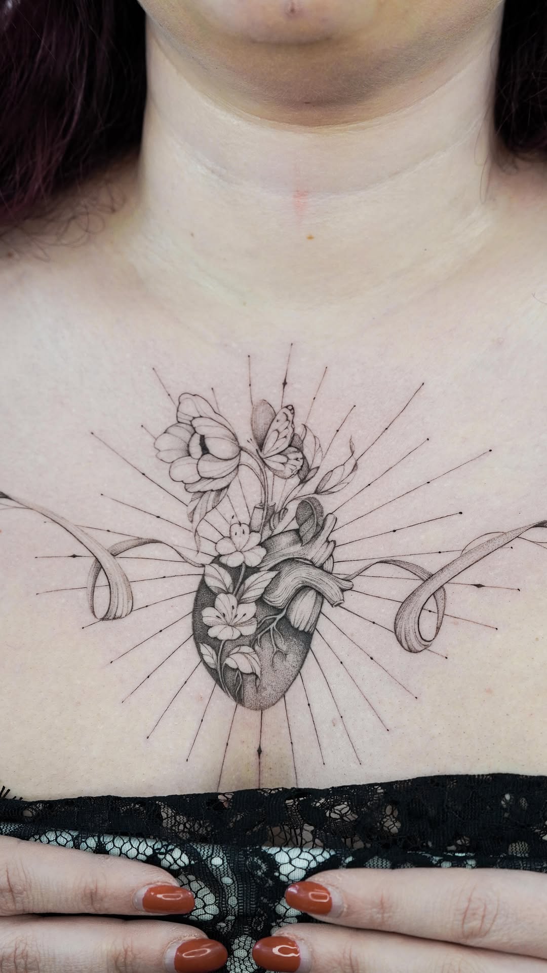 Anatomical heart centerpiece intertwined with blooming flowers and radiant lines