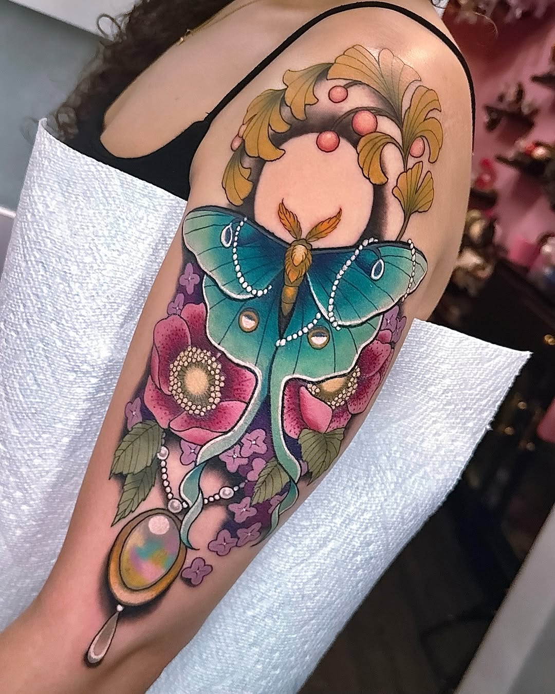 Vibrant teal butterfly, pearl accents, blooming vines, opal pendant