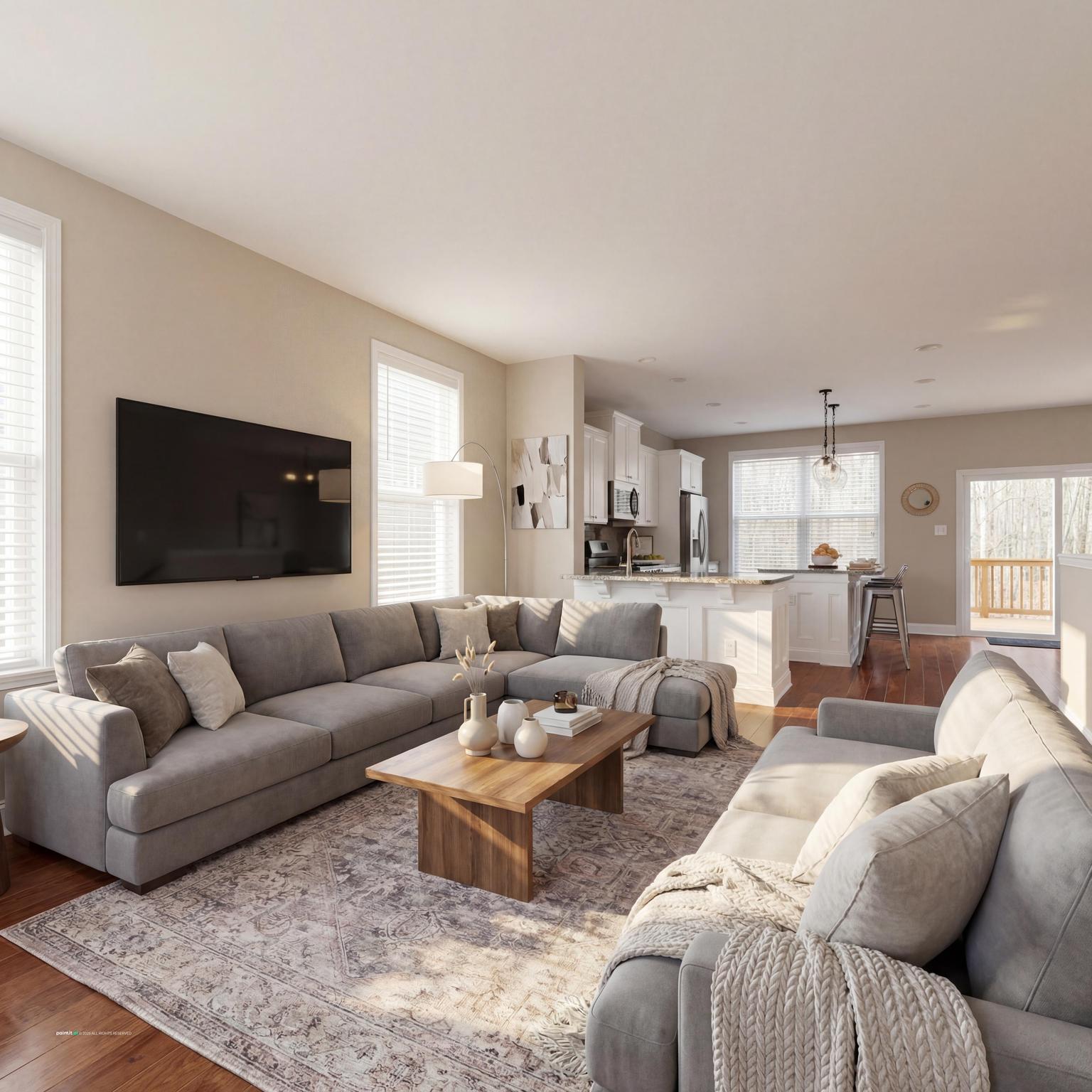 Grey sectional in an open living and dining room with a wooden coffee table