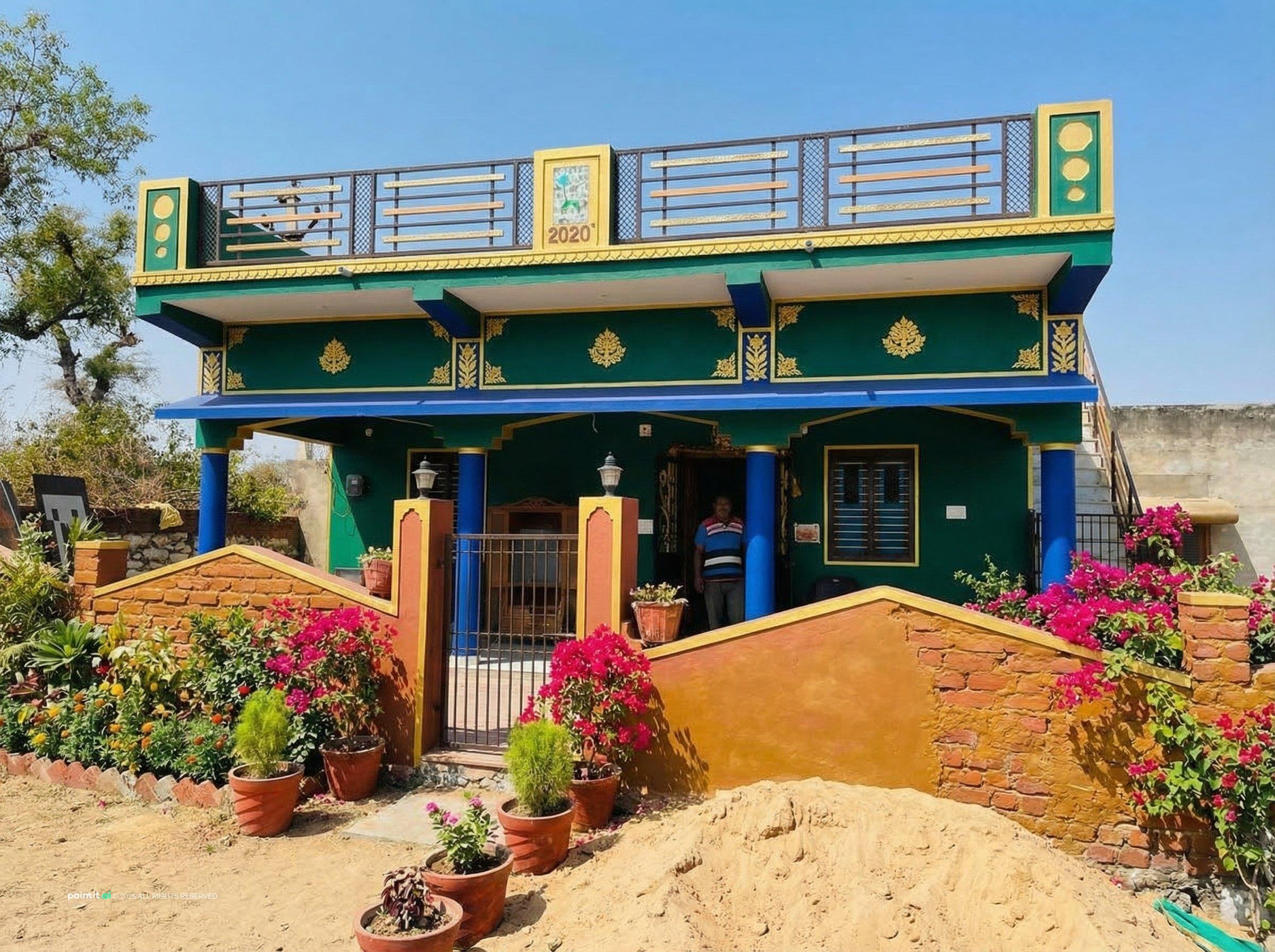 House in Rajasthan painted in royal green, blue and yellow with carved details and flower beds