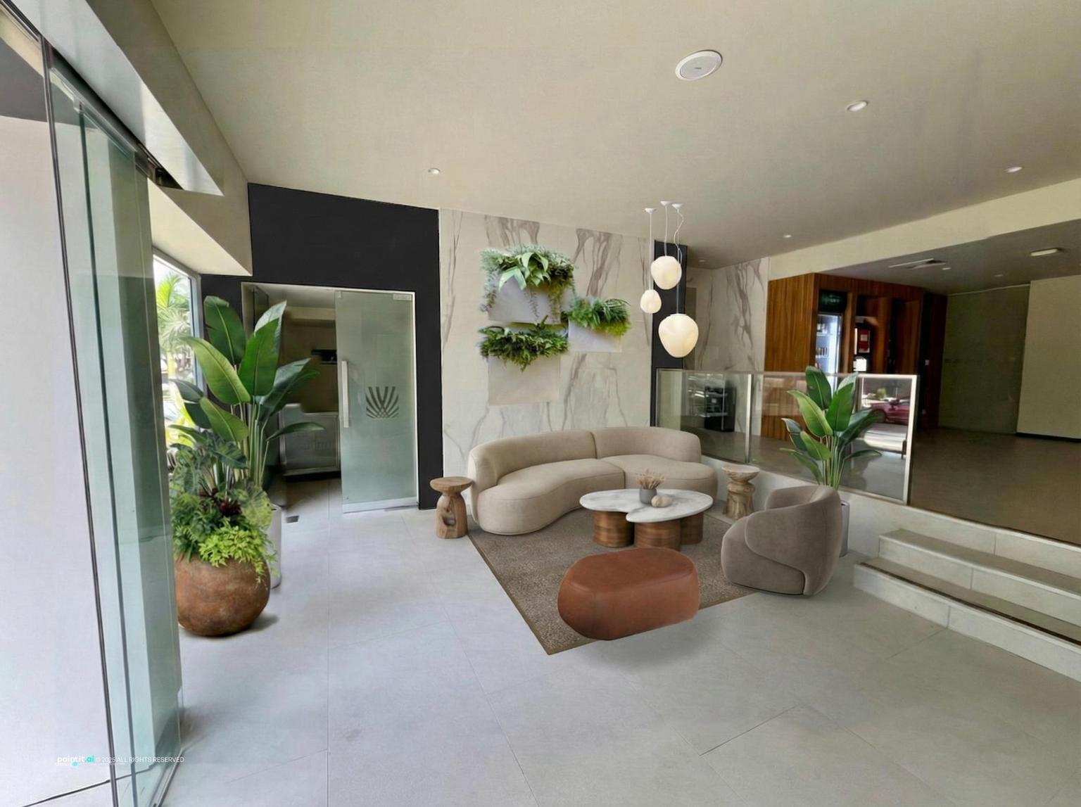 Hotel lobby with a curved cream sofa, round coffee tables, a marble feature wall and potted plants