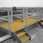 FRP grating platform installed on a roof in an industrial setting.