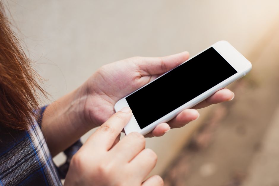 Açık havada akıllı telefon kullanan kişi