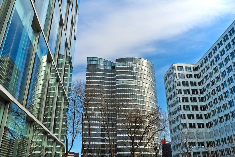 Modern corporate headquarters with glass facade reflecting the sky