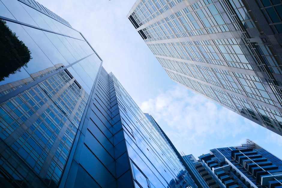 Low angle view of modern skyscrapers reflecting the sky