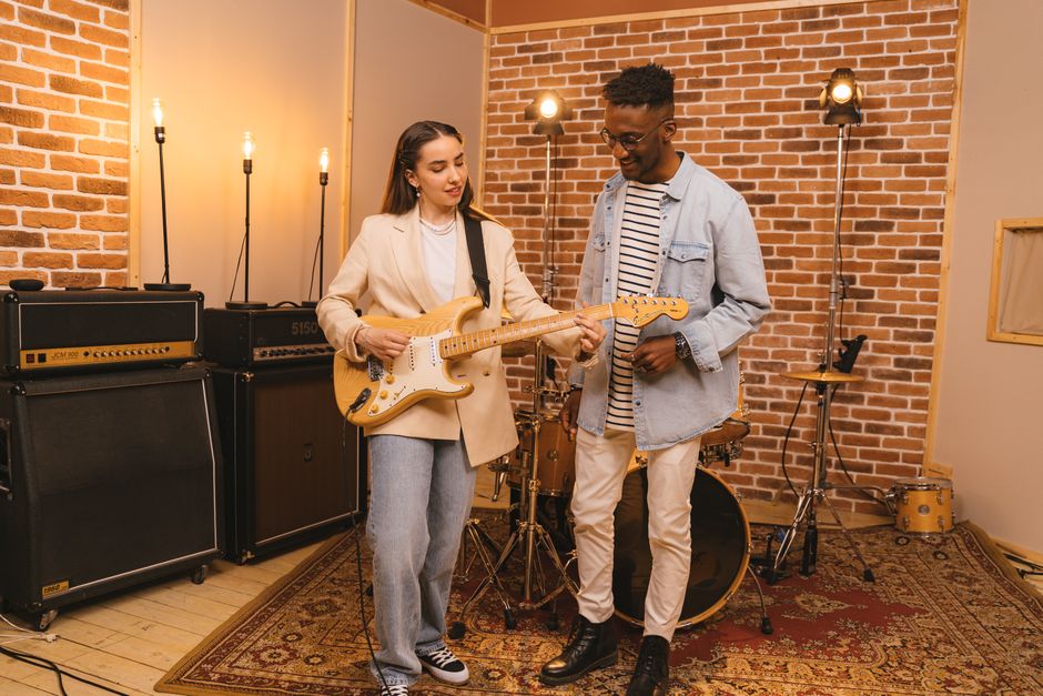 Young musicians rehearsing in studio with guitar and violin