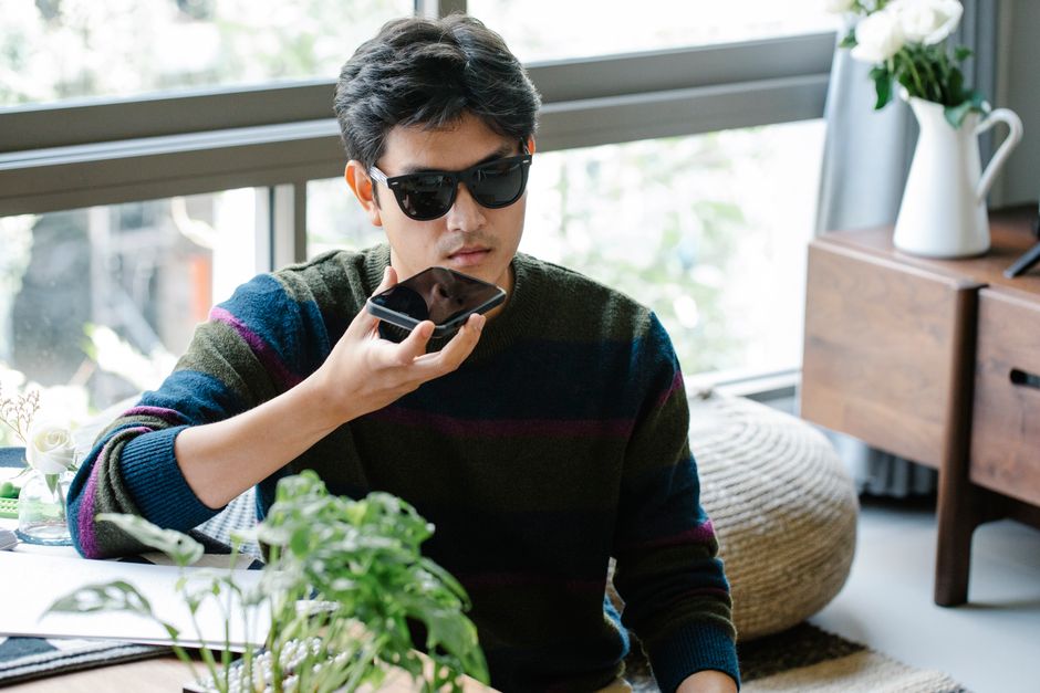 Man using smartphone voice assistant with sunglasses