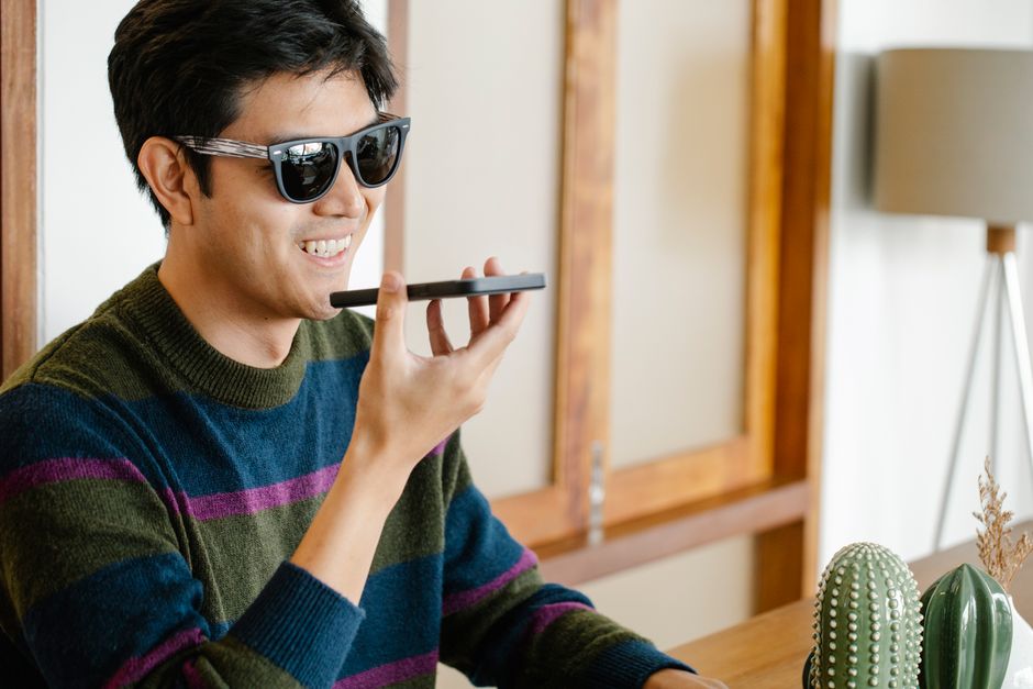 Young man using voice features on smartphone