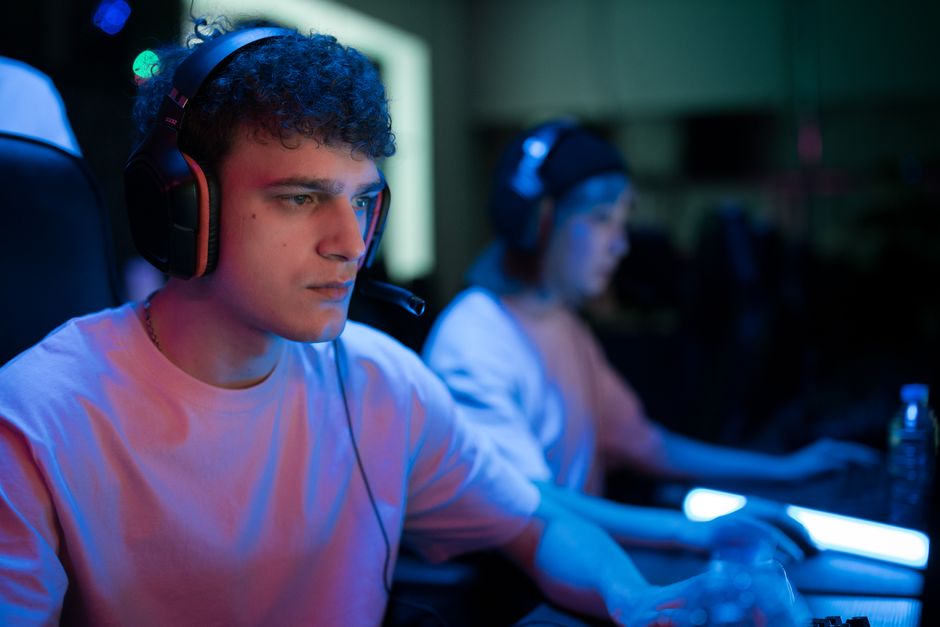 Gamer with headset in intense gaming session under neon lights
