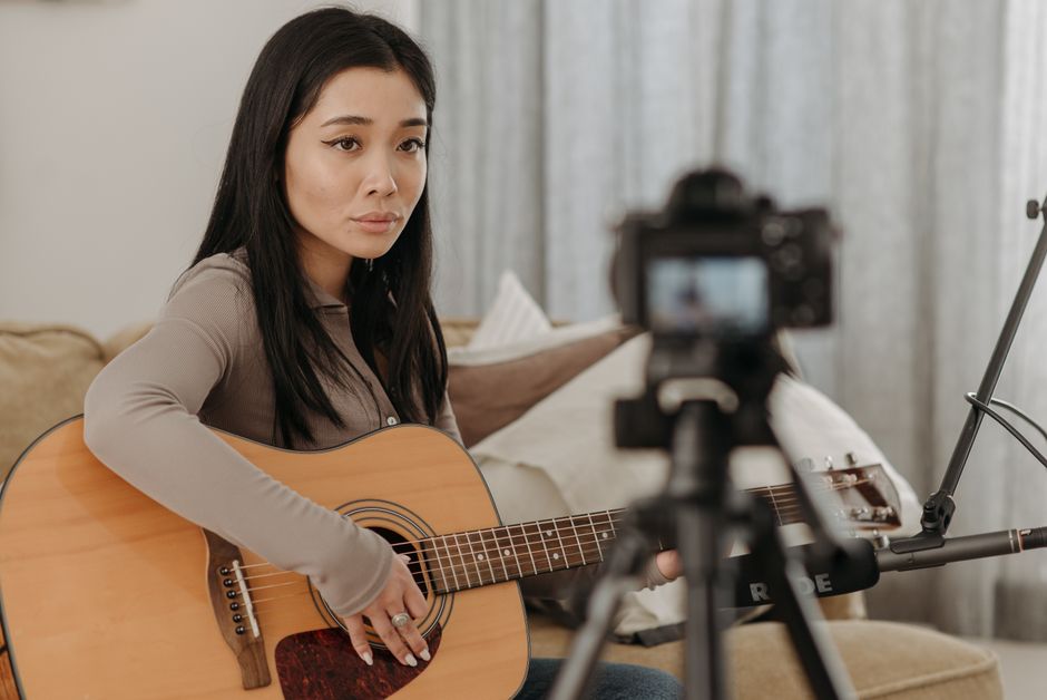 Woman playing acoustic guitar online
