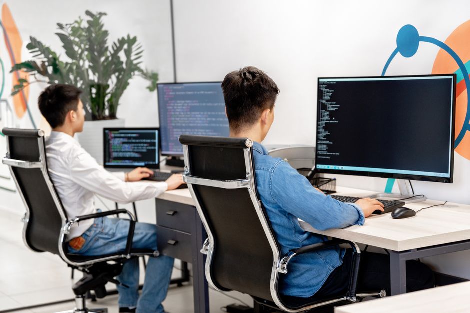 Two developers programming in modern office