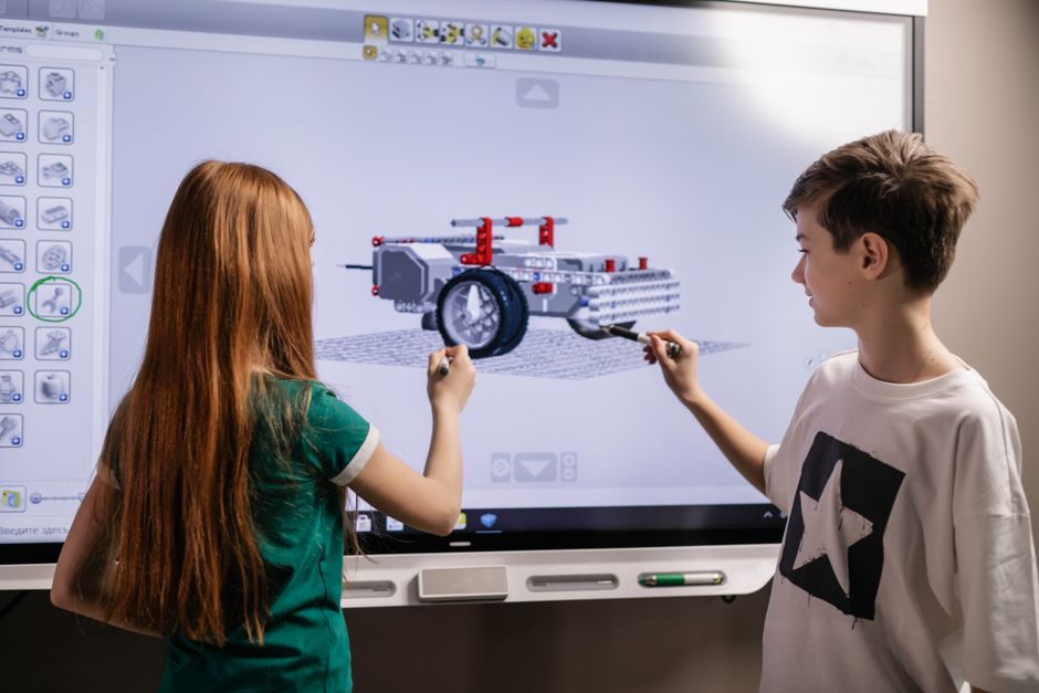 A boy and girl collaborate on a robotics project