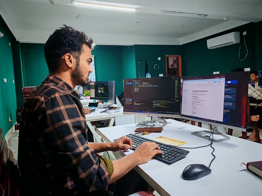 Software developer coding on dual monitors