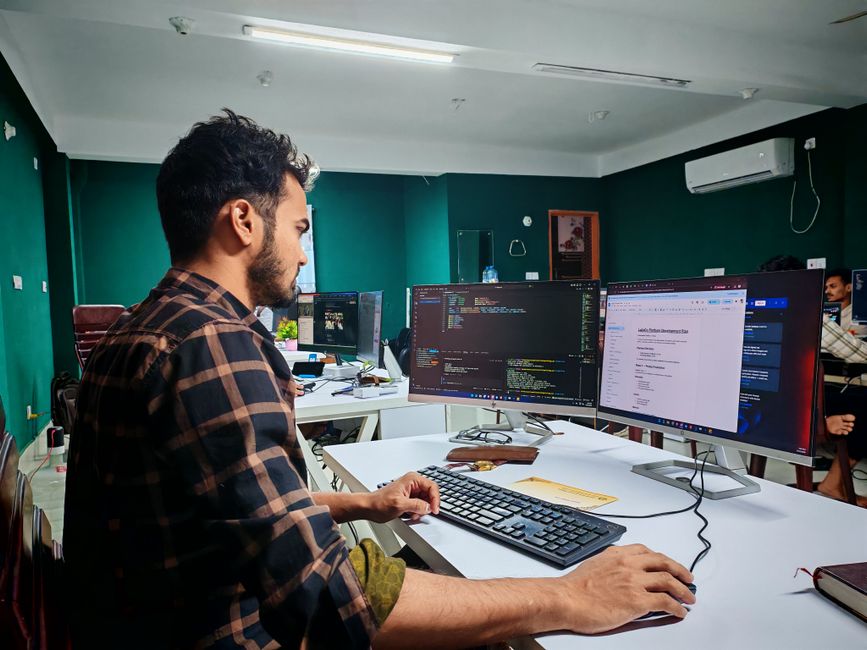 Software developer coding on dual monitors