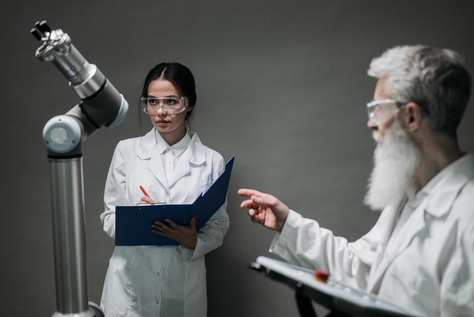 Scientists in lab coats analyze advanced robotics technology