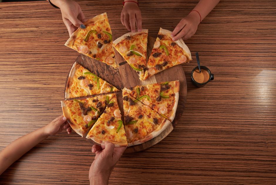 Üstten pizza paylaşımı