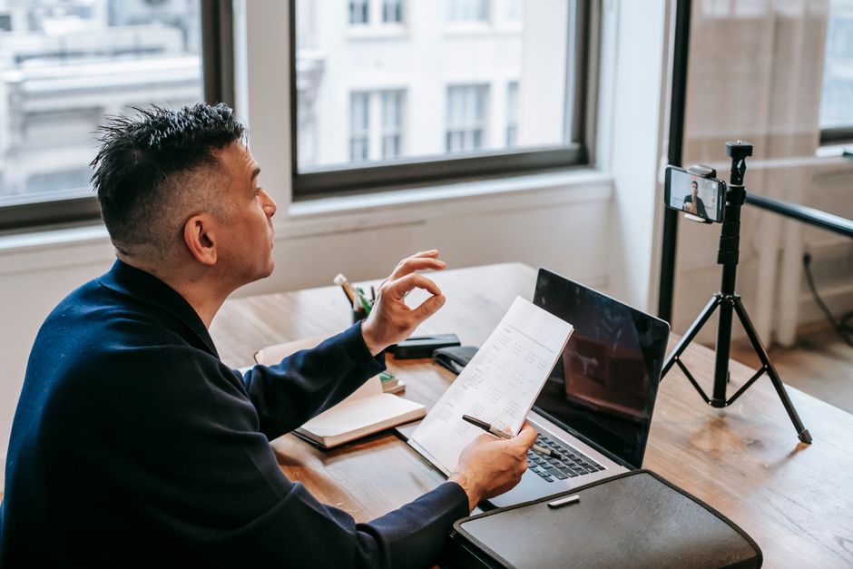 Man using laptop and smartphone for video call