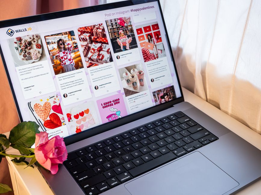 Laptop showcasing social media wall with vibrant posts