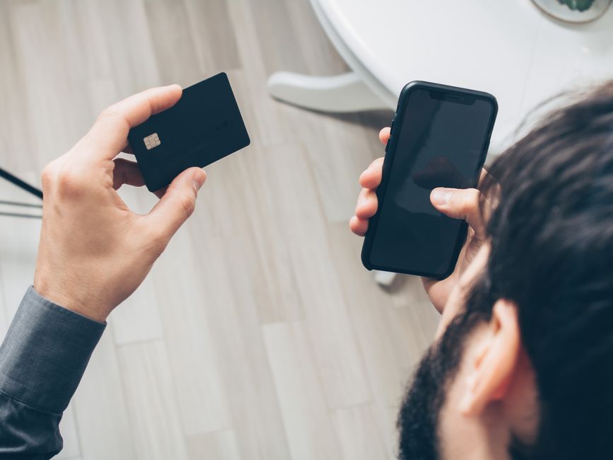 Akıllı telefon ve kredi kartıyla dijital ödeme yapan kullanıcı