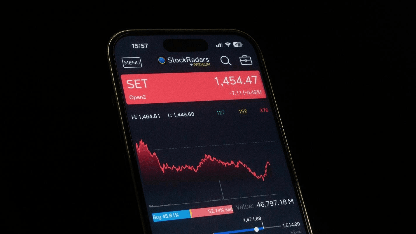 Smartphone displaying a red stock market chart with price decline data. 