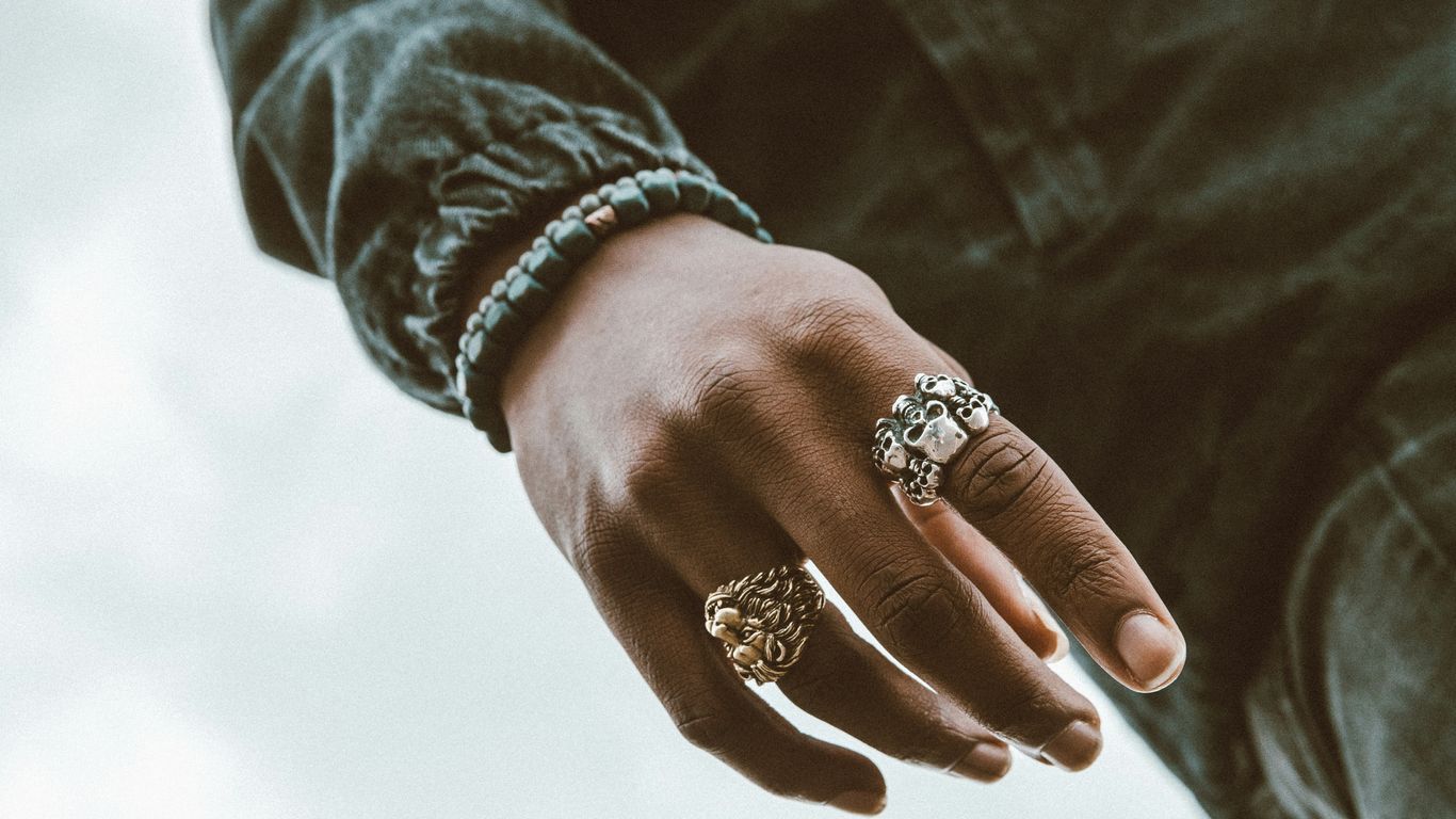 a close up of a person's hand with a ring on it