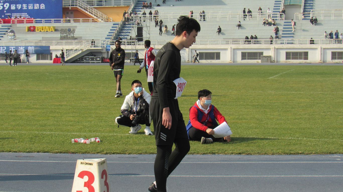 man in black and white long sleeve shirt and black pants sitting on green grass field