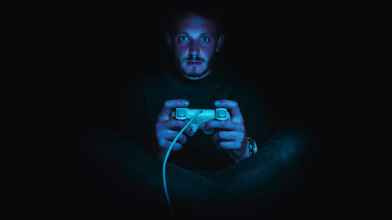 man holding corded game controller