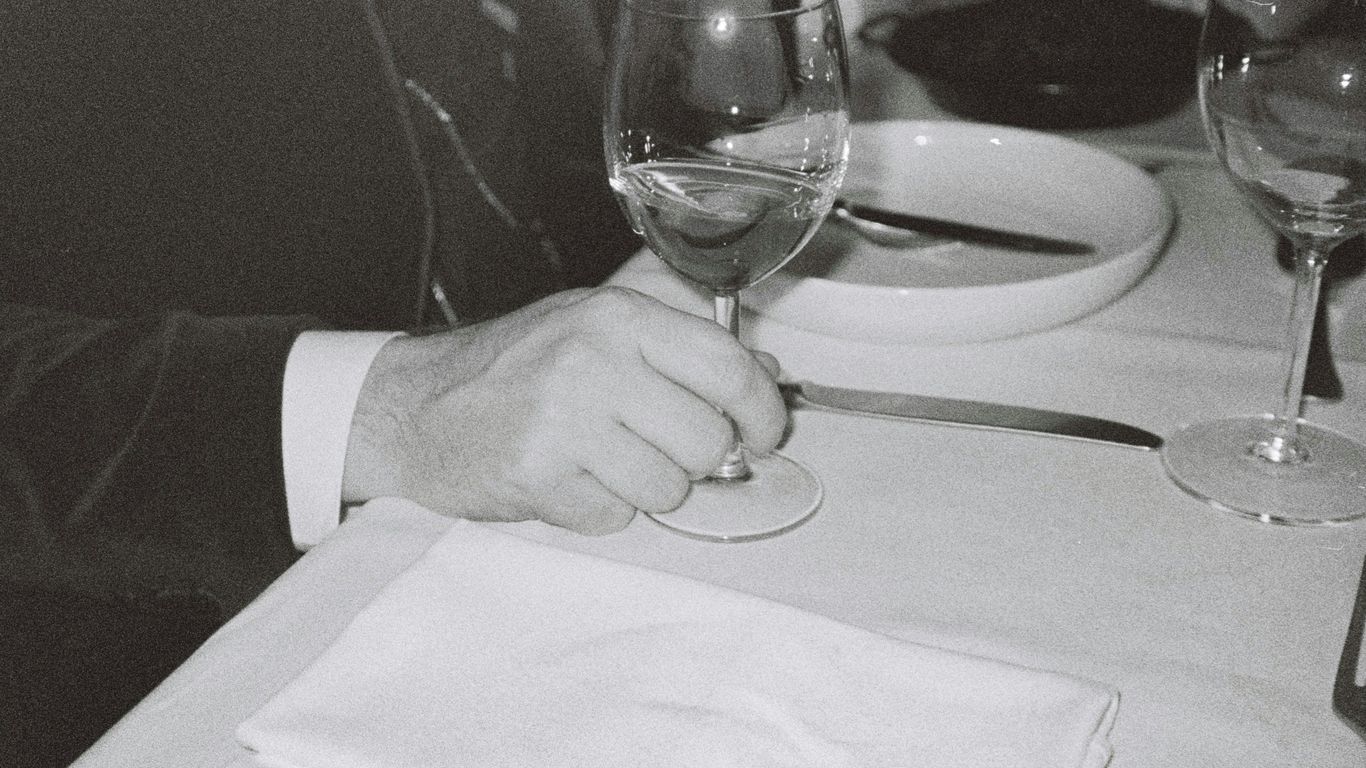 man touching near empty wineglass