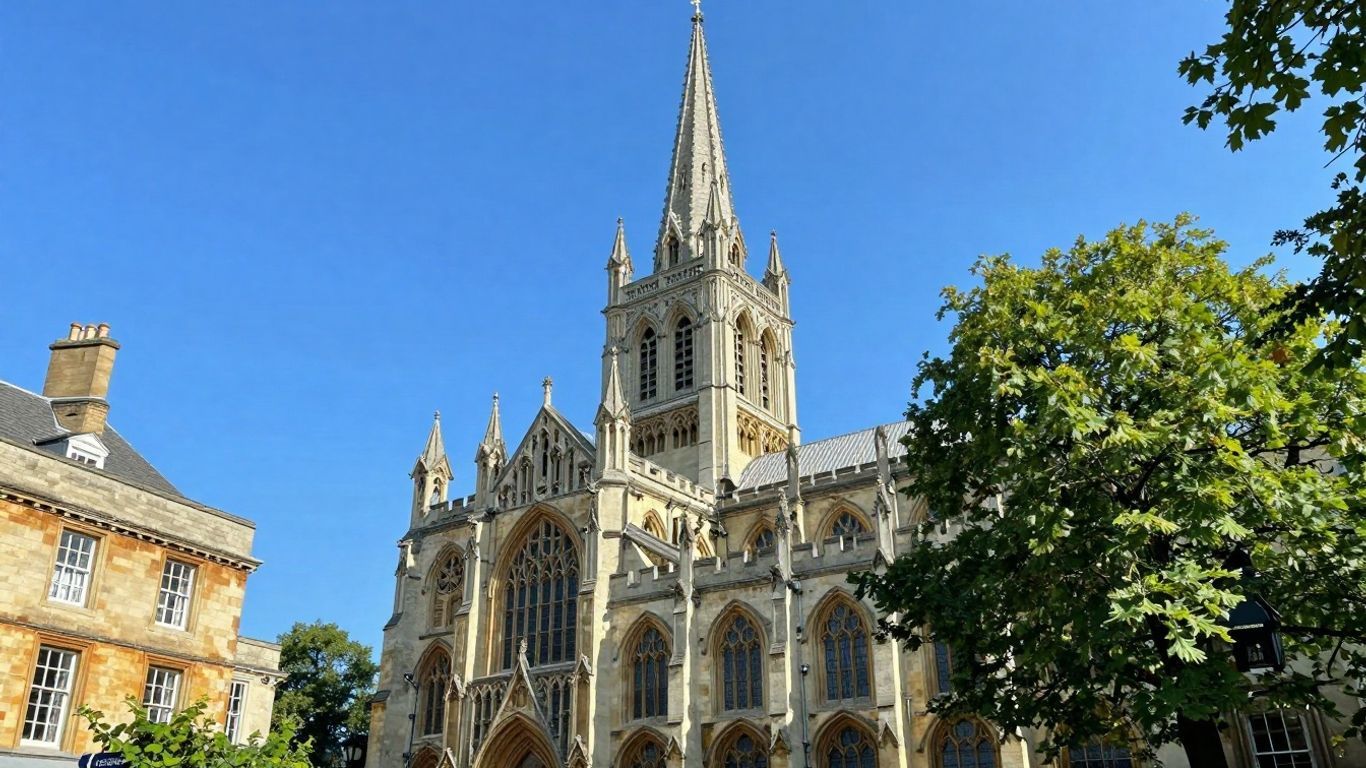 Historic English cathedral spire against a blue sky.