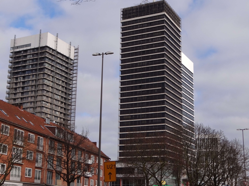 Außenansicht der Hamburger Straße 3 in Hamburg 20083 mit zwei Hochhäusern im Bau, umgeben von niedrigeren Wohngebäuden und kahlen Bäumen unter bewölktem Himmel