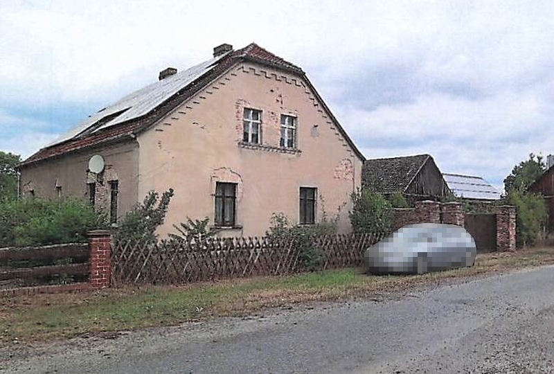Einfamilienhaus in Tauche OT Briescht, An der Spree 7, mit verputzter Fassade, Satteldach und Holzzaun im Vorgarten. Satellitenschüssel und Fenster sichtbar