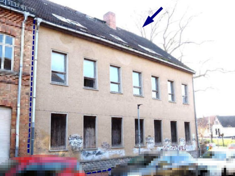 Gewerbeobjekt in Schulstraße 36, 06295, mit beigefarbener Fassade, mehreren Fenstern und Dach mit Schornstein; Graffiti an der Wand