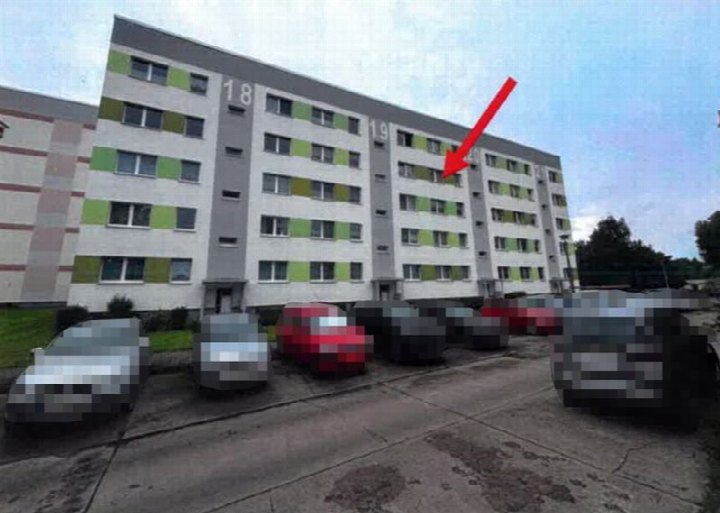 Fassade eines Mehrfamilienhauses mit den Hausnummern 18, 19 und 20, grün-weiße Fassadenelemente, geparkte Fahrzeuge im Vordergrund, Birkholzer Weg 20, Magdeburg