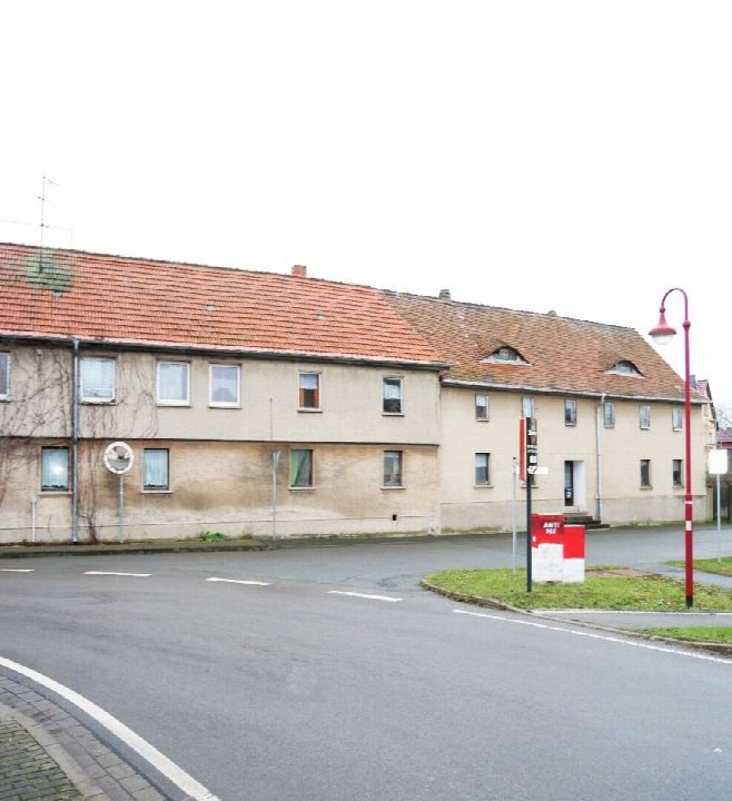 Einfamilienhaus in Am Ettersberg OT Vippachedelhausen 2, Ansicht der Seitenfassade mit rotem Ziegeldach und beigefarbener Wand, Straßenanschluss mit Laternenmast und Briefkasten
