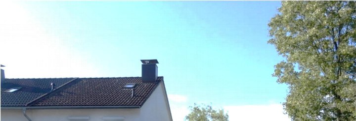 Dachansicht der Garage in Wuppertal, Stockmannsmühle 99, mit braunen Ziegeln, Dachfenster und Schornstein unter klarem Himmel