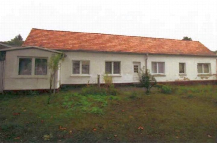 Seitenansicht eines Zweifamilienhauses in Seebad Ahlbeck, Ritterstraße 12, mit weißer Fassade, rotem Ziegeldach und vorgelagertem Grünstreifen