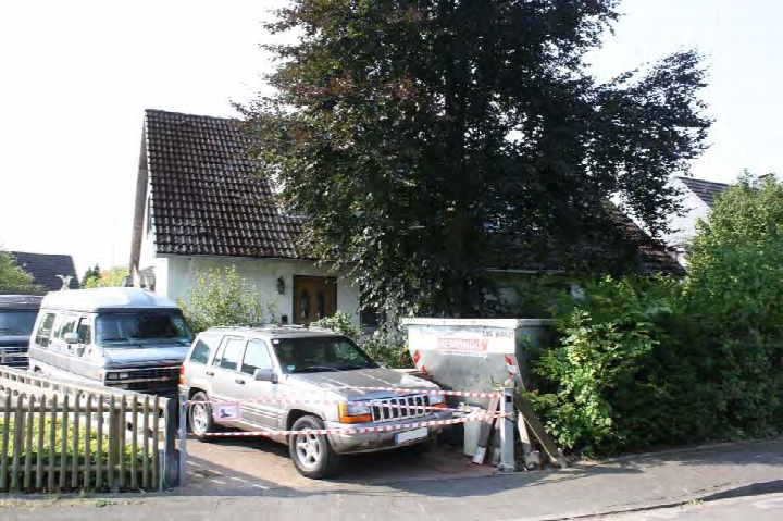 Garage und Parkplatz vor Zweifamilienhaus in Ratingen, An den Schlothen 9, 9a, mit geparkten Fahrzeugen und Absperrband
