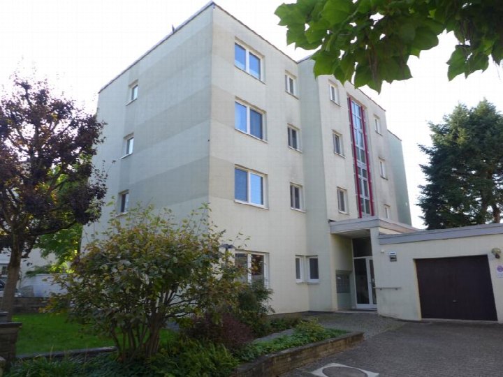Mehrfamilienhaus mit hellen Fassaden, Fenstern und Eingangsbereich, umgeben von Grünanlagen und Bäumen, Kalbacher Hauptstraße 60 c, Frankfurt am Main