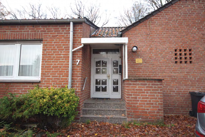 Eingangsbereich einer Backsteinhaushälfte mit weißer Doppeltür, Stufen, Hausnummer 7 und Vordach. Eibischweg 7, Marl
