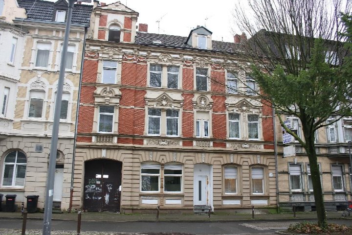 Fassade eines mehrstöckigen Wohnhauses in Gelsenkirchen, Josefstraße 17, mit roten Ziegeln und verzierten Fenstereinfassungen