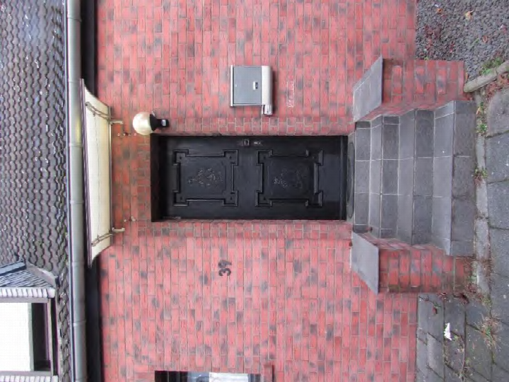 Eingangsbereich mit schwarzer Doppeltür, rotem Backsteinmauerwerk und Hausnummer 39, Behringstraße 39, Bergheim