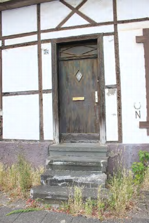 Eingangsbereich eines Einfamilienhauses mit Holztür, Steinstufen und Fachwerkfassade, Saarstraße 34, Recklinghausen