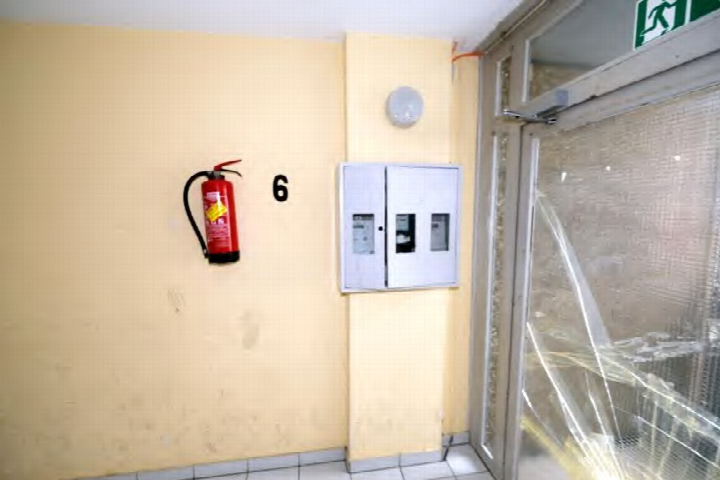 Treppenhaus mit Feuerlöscher, Notausgangsschild und elektrischem Schaltkasten in einer Eigentumswohnung in Frankfurt am Main